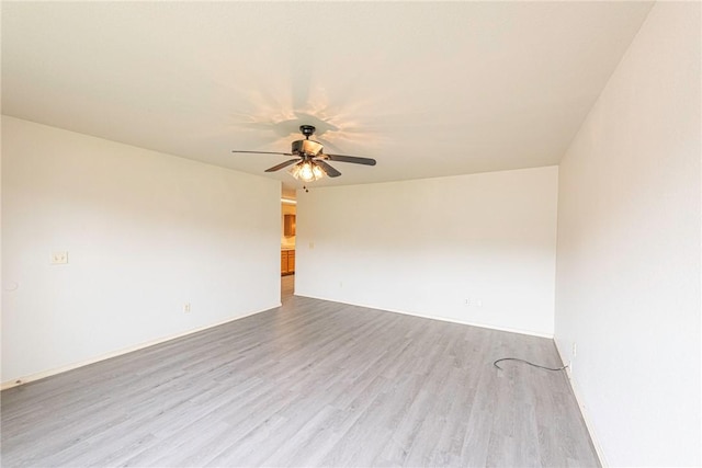 unfurnished room featuring baseboards, a ceiling fan, and wood finished floors