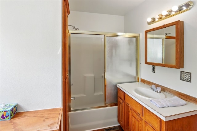 full bathroom with vanity, enclosed tub / shower combo, and visible vents