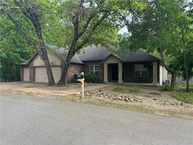 single story home with roof with shingles, an attached garage, concrete driveway, and brick siding