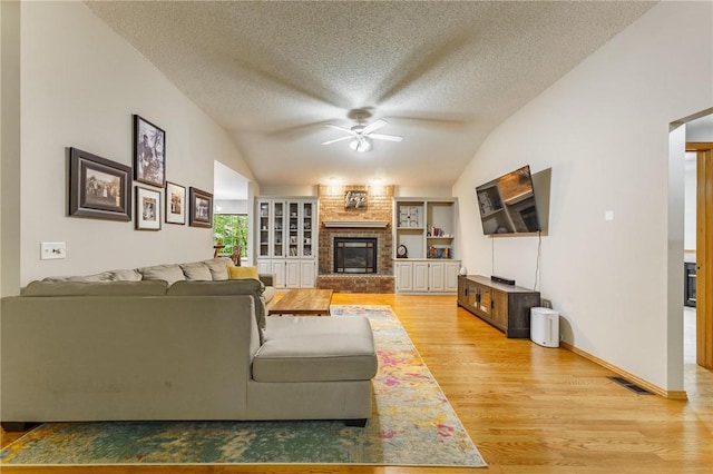 2 Saxilby Ln, Bella Vista, AR 72715 - living room with visible vents, light wood-style floors, ceiling fan, a textured ceiling, and vaulted ceiling