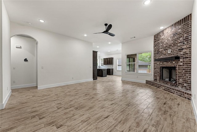4 Lothian Dr, Bella Vista, AR 72715 - unfurnished living room with ceiling fan, light wood finished floors, arched walkways, baseboards, and recessed lighting