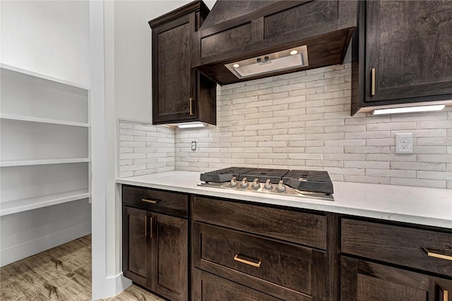 4 Lothian Dr, Bella Vista, AR 72715 - kitchen featuring dark brown cabinetry, custom range hood, tasteful backsplash, and light countertops