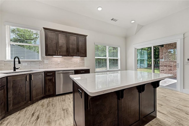 4 Lothian Dr, Bella Vista, AR 72715 - kitchen featuring stainless steel dishwasher, a sink, light wood-style flooring, dark brown cabinetry, and vaulted ceiling