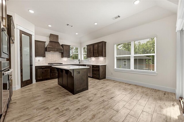 4 Lothian Dr, Bella Vista, AR 72715 - kitchen with premium range hood, dark brown cabinets, gas stovetop, a kitchen island, and light countertops