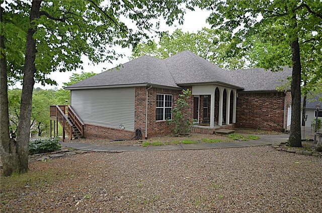 3 Evelynia Cir, Bella Vista, AR 72715 - view of side of home featuring a shingled roof, stairway, and brick siding