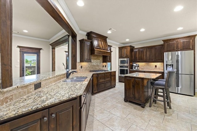 kitchen featuring dark brown cabinets, appliances with stainless steel finishes, a sink, and tasteful backsplash