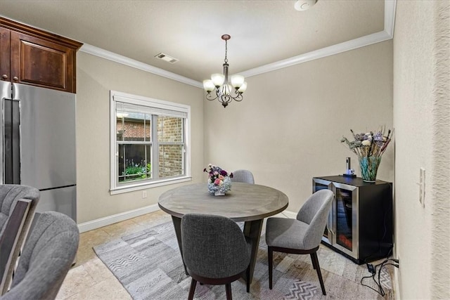 dining space featuring an inviting chandelier, beverage cooler, baseboards, visible vents, and ornamental molding