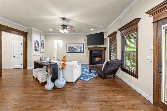living room featuring recessed lighting, ornamental molding, ceiling fan, and a lit fireplace