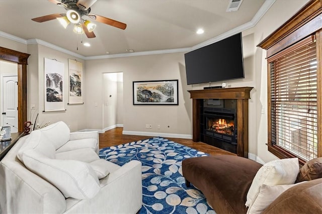 living area featuring a glass covered fireplace, a ceiling fan, recessed lighting, wood finished floors, and visible vents