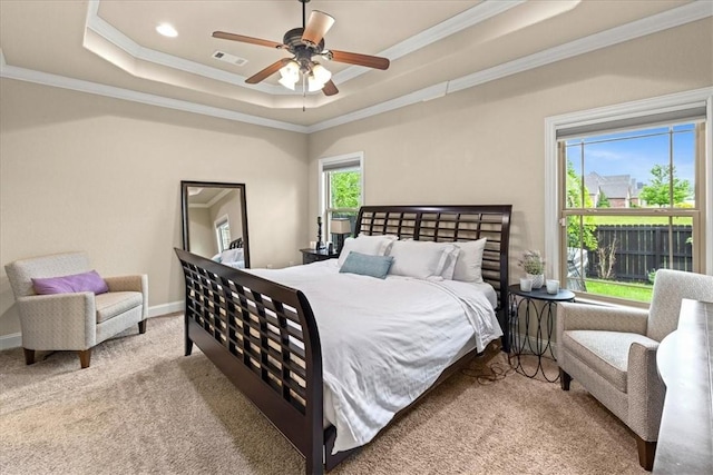 carpeted bedroom with a tray ceiling, visible vents, and ornamental molding