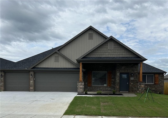 craftsman house with board and batten siding, a front yard, a garage, brick siding, and concrete driveway
