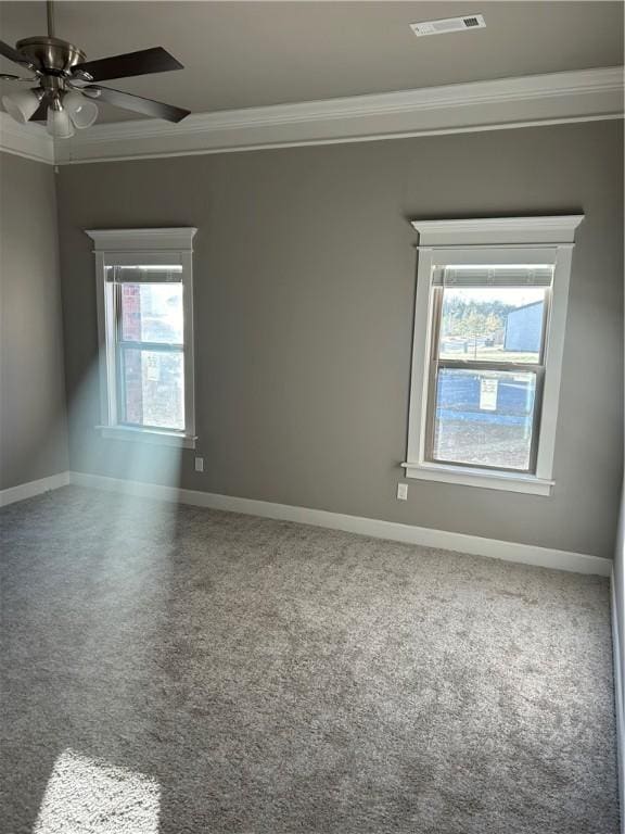 empty room featuring crown molding, a ceiling fan, baseboards, and visible vents