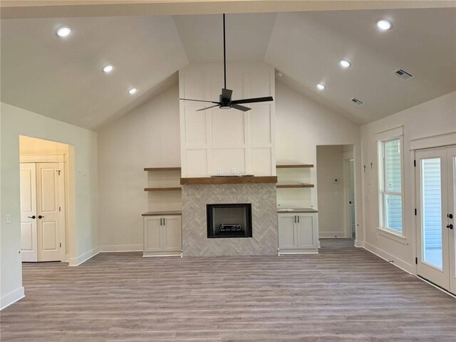 unfurnished living room featuring high vaulted ceiling, a ceiling fan, light wood-style flooring, and visible vents