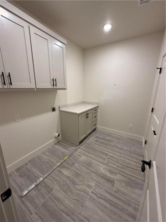 clothes washing area with cabinet space, recessed lighting, electric dryer hookup, and baseboards
