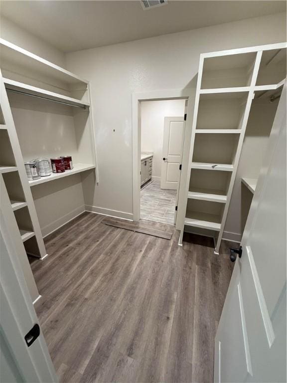 walk in closet with wood finished floors and visible vents