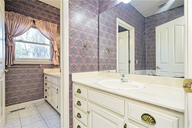 bathroom featuring visible vents, vanity, and wallpapered walls