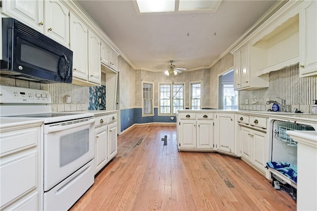 kitchen with a peninsula, black microwave, white range with electric cooktop, white cabinets, and light wood-style flooring