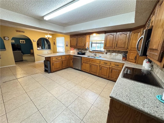 60 N Redwood Cir, Sallisaw, OK 74955 - kitchen featuring light countertops, a peninsula, a textured ceiling, and appliances with stainless steel finishes