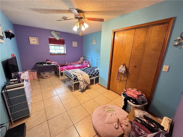 60 N Redwood Cir, Sallisaw, OK 74955 - bedroom with a closet, a ceiling fan, a textured ceiling, and light tile patterned flooring