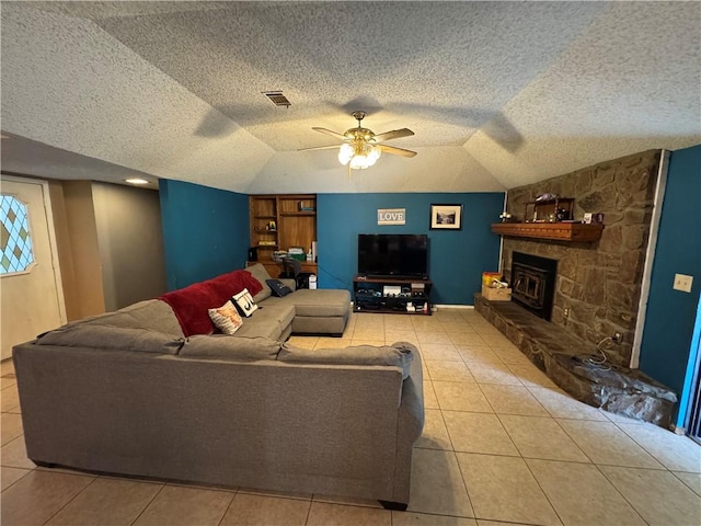 60 N Redwood Cir, Sallisaw, OK 74955 - tiled living room with a ceiling fan, a textured ceiling, vaulted ceiling, and a fireplace