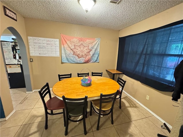 60 N Redwood Cir, Sallisaw, OK 74955 - dining room featuring arched walkways, a textured ceiling, and light tile patterned floors