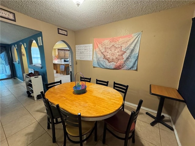 60 N Redwood Cir, Sallisaw, OK 74955 - dining space featuring arched walkways, a textured ceiling, and light tile patterned floors