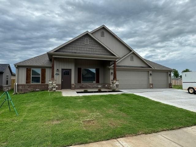 craftsman inspired home with a garage, concrete driveway, and a front yard