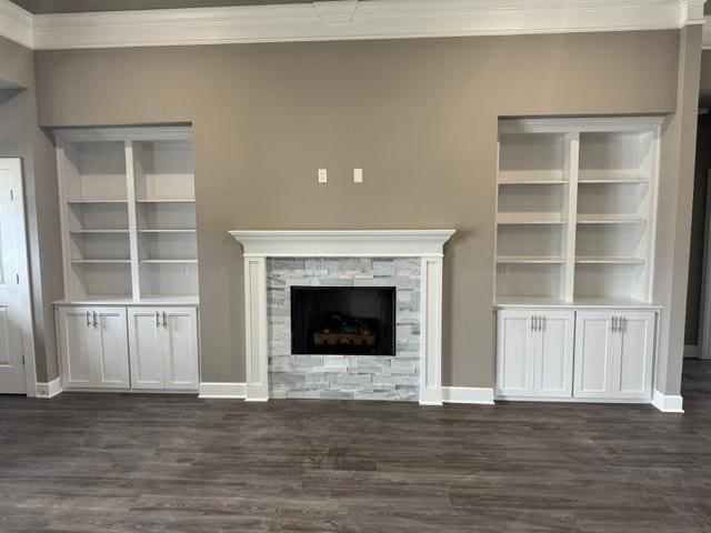unfurnished living room featuring crown molding, baseboards, dark wood finished floors, and a fireplace