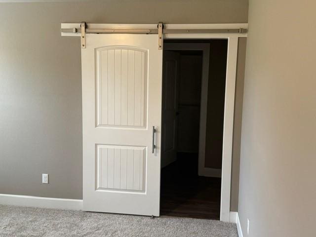 corridor with baseboards and carpet flooring
