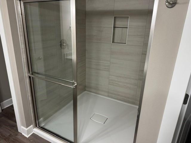 bathroom with baseboards and a shower stall