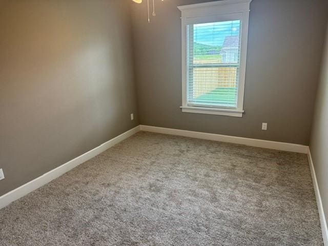 empty room featuring baseboards and carpet