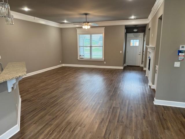 681 Baggett St, Prairie Grove, AR 72753 - unfurnished living room featuring a ceiling fan, dark wood-style flooring, a fireplace, baseboards, and ornamental molding