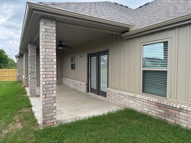 681 Baggett St, Prairie Grove, AR 72753 - rear view of property featuring ceiling fan, fence, brick siding, a shingled roof, and board and batten siding