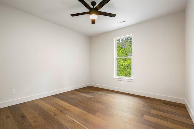spare room featuring baseboards, a ceiling fan, hardwood / wood-style flooring, and visible vents