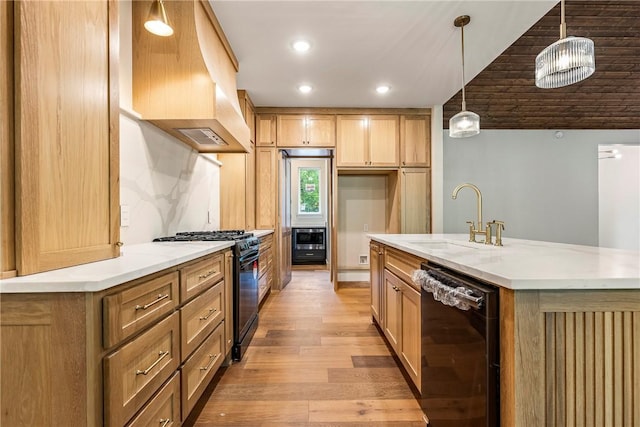 kitchen featuring custom exhaust hood, light wood-style floors, recessed lighting, a sink, and black appliances