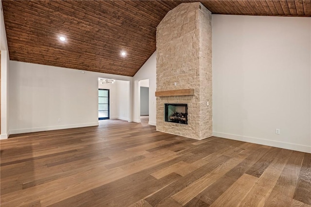 unfurnished living room featuring a stone fireplace, high vaulted ceiling, wood finished floors, and wooden ceiling