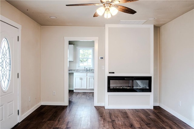 foyer with baseboards, ceiling fan, wood finished floors, and visible vents