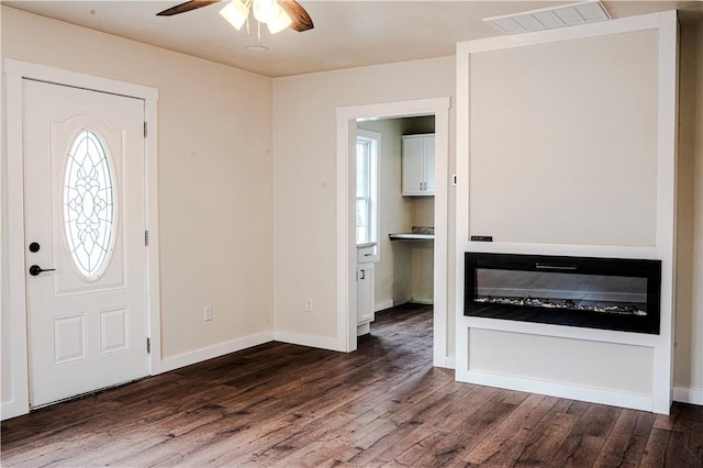 foyer entrance featuring ceiling fan, visible vents, dark wood-style floors, and a healthy amount of sunlight