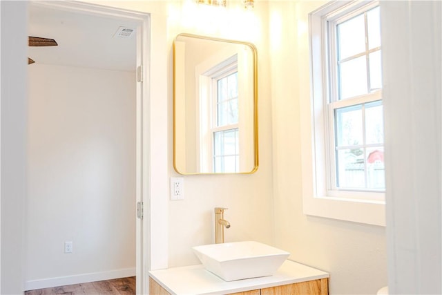 bathroom with visible vents, plenty of natural light, wood finished floors, and vanity