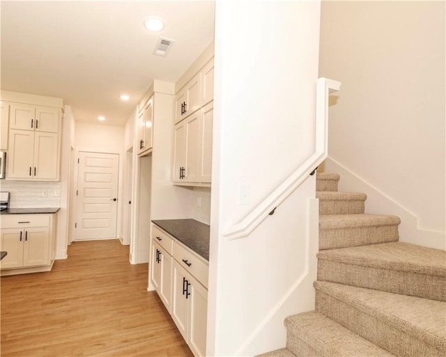 stairs featuring recessed lighting, wood finished floors, and visible vents