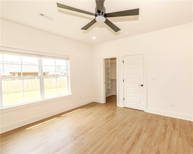 unfurnished room featuring baseboards, ceiling fan, visible vents, and light wood-type flooring