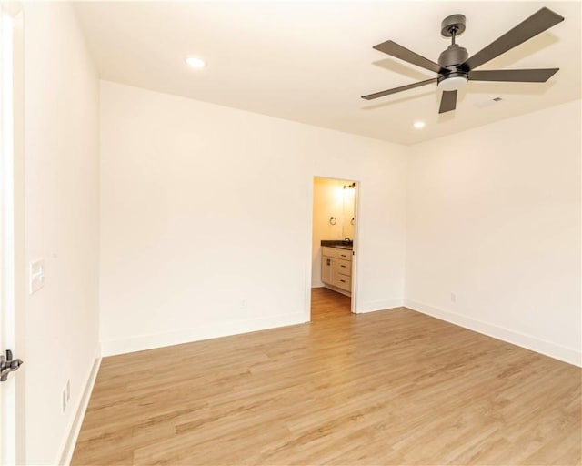 unfurnished room with light wood-style floors, a ceiling fan, and baseboards