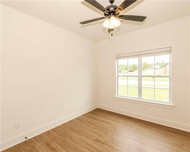 empty room with a ceiling fan, baseboards, and light wood-style flooring