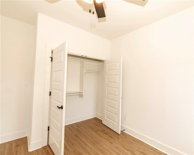 unfurnished bedroom with a closet, baseboards, ceiling fan, and light wood-style floors