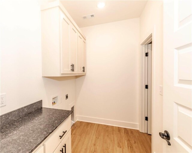 laundry area with cabinet space, light wood finished floors, hookup for a washing machine, hookup for an electric dryer, and visible vents