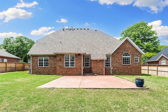 rear view of house featuring a yard, brick siding, and fence