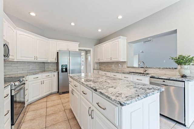 kitchen with a sink, a center island, tasteful backsplash, and stainless steel appliances