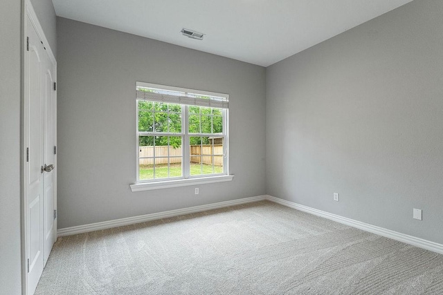 carpeted spare room featuring visible vents and baseboards