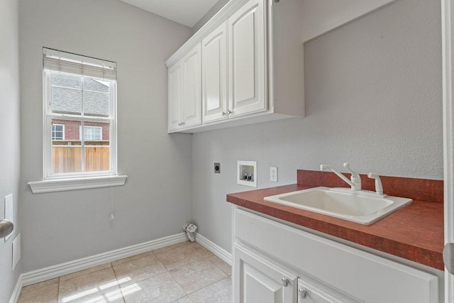 washroom with hookup for an electric dryer, cabinet space, a sink, baseboards, and hookup for a washing machine