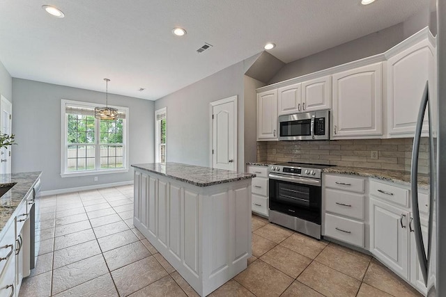 kitchen with white cabinets, stainless steel appliances, recessed lighting, tasteful backsplash, and a kitchen island